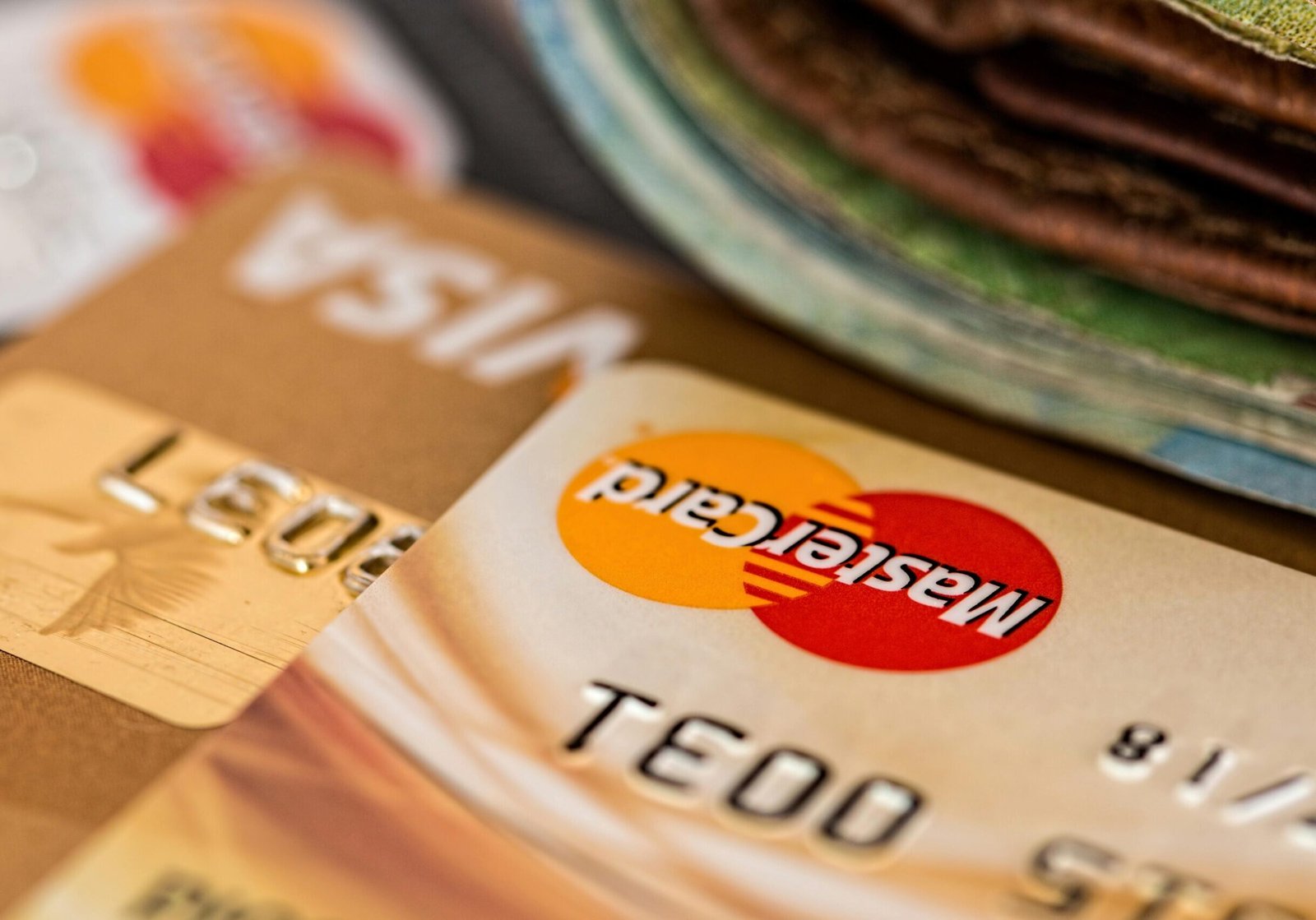 Macro shot of credit cards showing Visa and Mastercard logos next to a wallet, ideal for finance themes.